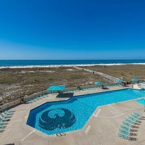 Sparkling pool area with turquoise lounge chairs overlooks the beach, providing a perfect spot for relaxation under the sun