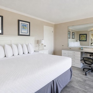 The master suite features a plush king bed, stylish artwork, and a convenient workspace with complimentary WiFi