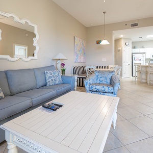 The living area features a light blue sofa with queen sleeper, decorative pillows, coffee table, and a cozy dining nook