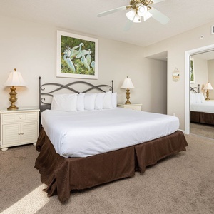 Rest in this inviting master bedroom on the beach featuring a king bed, soft carpet, and tasteful decor for a relaxing stay