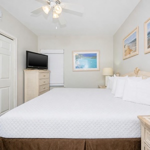 Enjoy your favorite show after a day at the beach in this inviting bedroom with a king bed and beach art