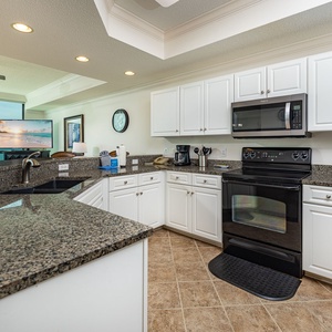 Prepare meals in this spacious kitchen featuring sleek appliances, ample counter space, and stylish cabinetry