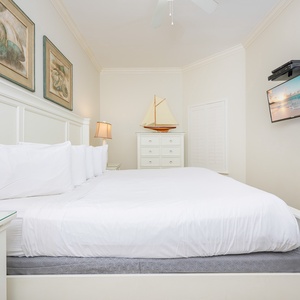Guest bedroom featuring a plush king bed, nautical decor, and a wall-mounted TV for cozy evenings