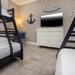 Unwind with a movie in this cozy bunk room with nautical accents and two twin over full bunk beds