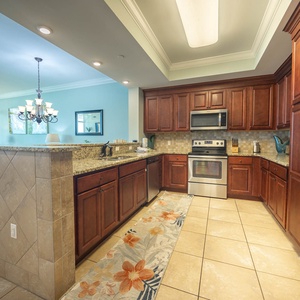 Prepare meals in the stylish kitchen with rich wood cabinetry, stainless appliances, and a decorative rug