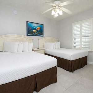 Get comfortable in this guest room with two double beds, soft linens, and cheerful beach-themed artwork