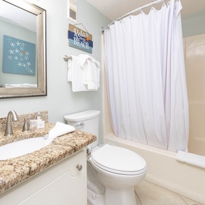 Bright and inviting bathroom featuring a granite countertop, modern fixtures, and a relaxing tub/shower combo