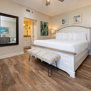Master bedroom featuring a king bed with soft linens, a stylish bench, and a warm color palette for a relaxing retreat