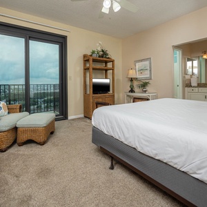 Relax in this master bedroom with a plush king bed, cozy seating, and balcony access with area views