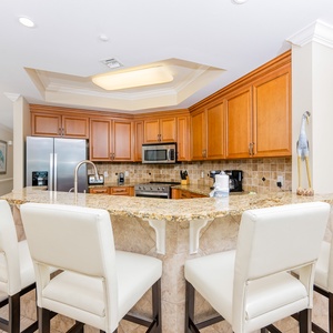 The kitchen features wood cabinetry, granite countertops, and stainless appliances, perfect for preparing meals