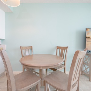 Dine at this charming table with a beachfront view, complemented by a TV and soft colors for a relaxing atmosphere