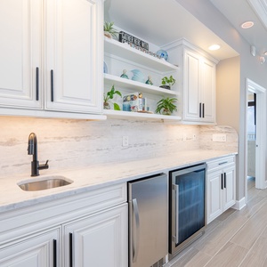 Enjoy preparing drinks at the wet bar with a wine cooler and coastal accents
