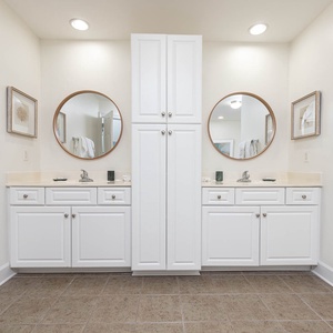 Refresh in the spacious master bathroom featuring dual sinks, round mirrors, and ample storage for your essentials