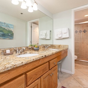 Experience the spacious double vanity area with elegant granite countertops and a relaxing walk-in shower