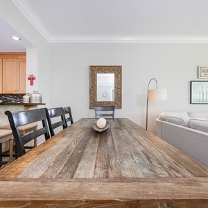 Gather around the rustic dining table, surrounded by inviting decor and a cozy living area for a relaxing meal