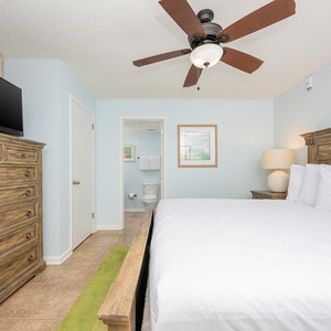 Brightly colored walls complement the inviting king bed, while a TV and dresser complete the cozy guest room atmosphere