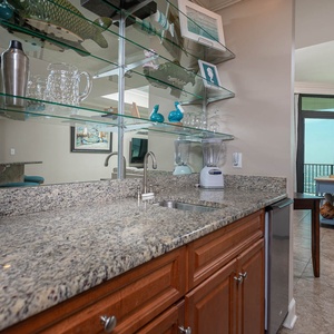 Grab a chilled drink or create a cocktail at this sleek wet bar with an elegant glassware display