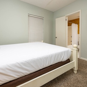 Rest in this inviting guest bedroom featuring a queen bed, soft carpet, and easy access to the adjoining bathroom