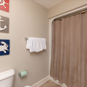 Embrace relaxation in this peaceful guest bath, featuring soft towels and coastal decor for a refreshing retreat
