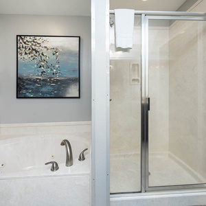 Indulge in relaxation with a spacious jetted tub and a walk-in shower, complemented by calming wall art