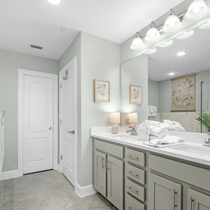 Refresh in the master bath after a day at the beach with a soothing tub and relaxing walk-in shower