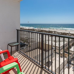 This balcony offers colorful seating and a stunning view of the beach, perfect for relaxation and enjoying the scenery