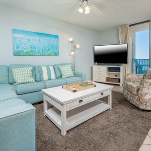 Relax in the inviting living area, featuring a plush sofa with queen sleeper, vibrant decor, and a view of the beach