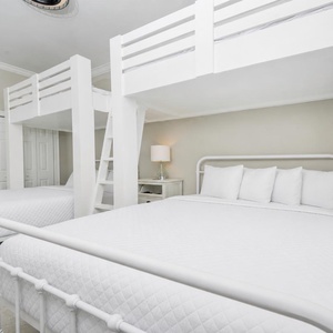 Relax in this cozy bunk room with two queen beds below two lofted twins for a cheerful sleeping arrangement