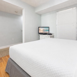 Sink into the plush queen bed and enjoy the cozy TV while feeling at home in this serene beach suite
