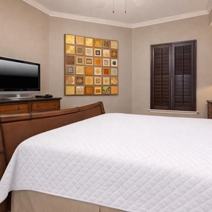Cozy master bedroom featuring a king bed, flat-screen TV, and warm decor, perfect for a restful getaway