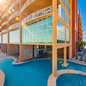 Experience the gradual entry pool with a waterslide and palm trees, just steps from the beautiful beach for a perfect getaway