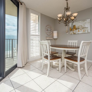 Dine at the round table under a chandelier while enjoying views through the large glass doors