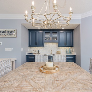 Experience delightful conversations around the rustic table, illuminated by the warm glow of the chandelier above