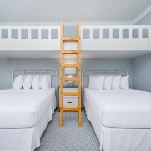 Experience comfort in this cheerful bedroom featuring two queen beds below and two lofted twins above