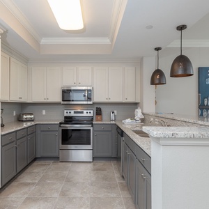 Enjoy creating culinary delights in this stylish kitchen, illuminated by elegant pendant lighting and modern design
