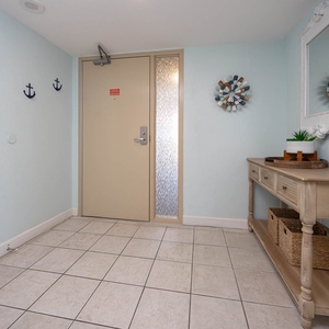Bright and inviting entryway featuring coastal decor, a stylish console table, and a welcoming atmosphere