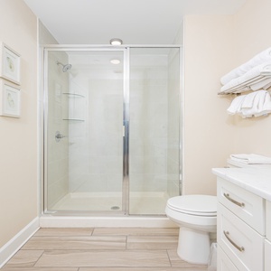 Bright guest bathroom featuring a spacious vanity, soft towels, and a walk-in shower