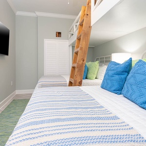 Relax in this guest bunk room with a movie after a day of adventure with two twin beds above two queens