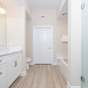 Refreshing master bath featuring a double vanity, relaxing tub, and walk-in shower