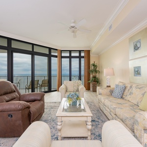 Inviting living area featuring a floral sofa with queen sleeper, a glass coffee table, and a soft cozy atmosphere