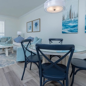 Relax in the inviting living area with coastal decor, sofa with queen sleeper, and a dining table for shared meals