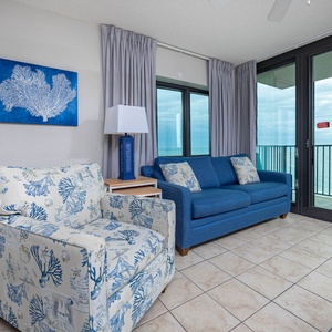 Unwind in the inviting living area with comfortable seating and large windows showcasing beautiful beach views