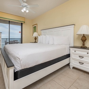 Unwind in the serene master bedroom featuring a comfortable king bed, stylish decor, and beachfront balcony access