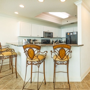 Enjoy meals at the stylish breakfast bar, surrounded by elegant decor and a view into the kitchen