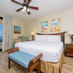 Experience comfort in the master bedroom featuring a king bed, beach art, and access to the inviting beach balcony