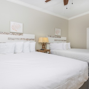Rest in this inviting guest room featuring two queen beds, soft linens, and tasteful decor