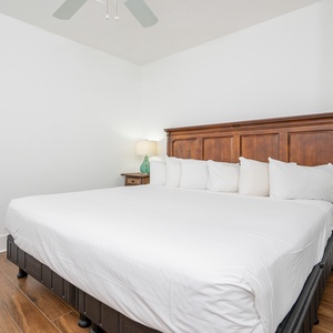 Inviting guest bedroom featuring a plush queen bed with soft white linens and warm wood accents for a cozy retreat