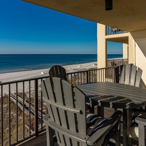 Relax on the private balcony with a round table and comfortable chairs, overlooking the tranquil beachfront and azure waters