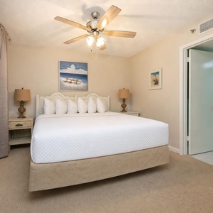 Guest suite with queen bed offers restful nights and warm light from ceiling fan lamps