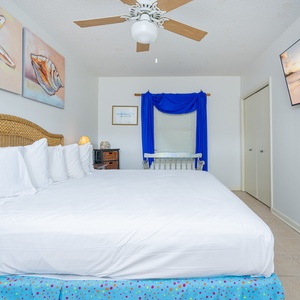 Relax in this spacious guest room featuring a king-size bed, colorful decor, and a flat-screen TV for entertainment